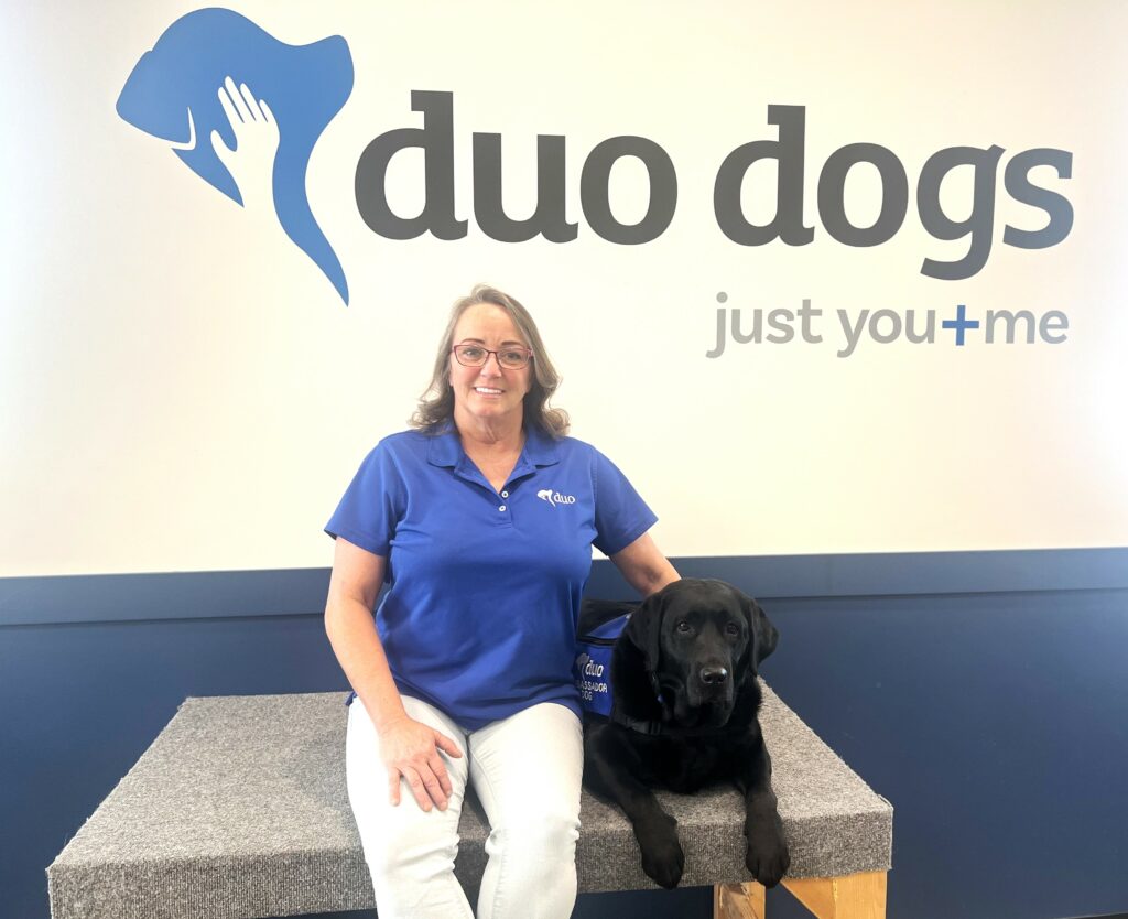 Crissy sitting next to Duo Dog Evie