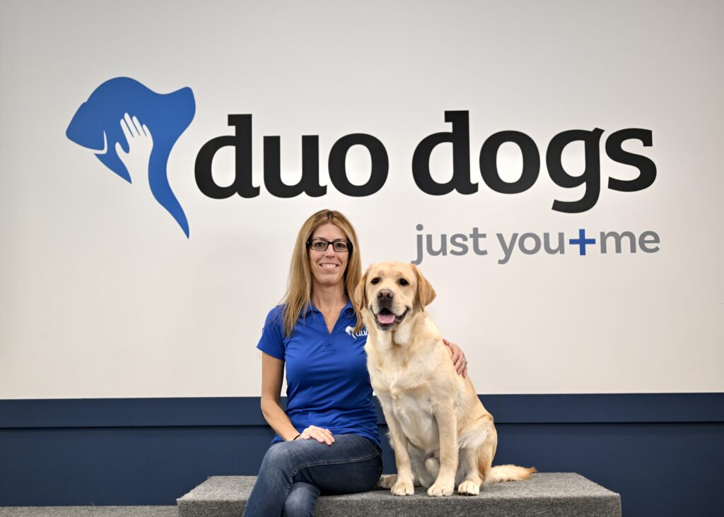 Tracy sitting with Duo Dog Woody